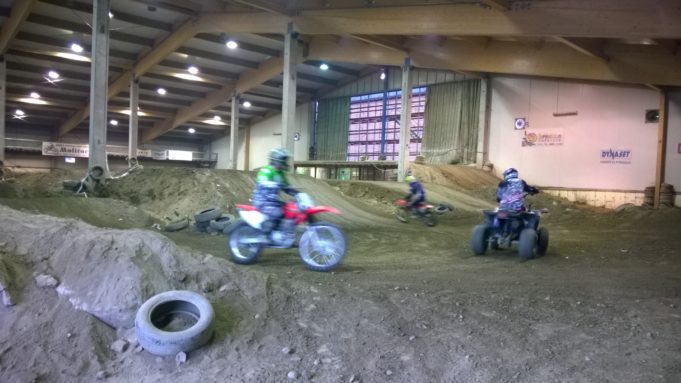 Nuoret offroad-radalla ajaa mopojen ja mönkijän kanssa ympyrää.