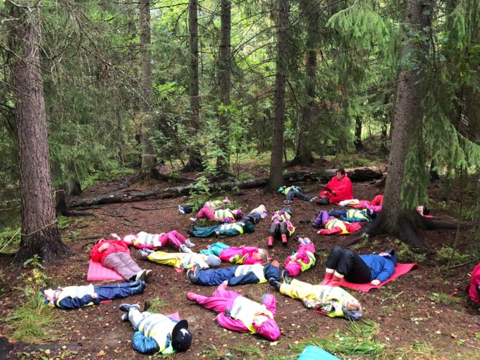 Luontorentoutus Alhoniityn päiväkodilla, jossa lapset rentoutuvat makaamalla maassa metsässä.