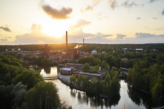 Nokian Tehdassaari kesäisenä aamuna auringon noustessa. Tehdassaaressa on vanhoja punatiilisiä rakennuksia ja edelleen toimivia tehtaita piippuineen.