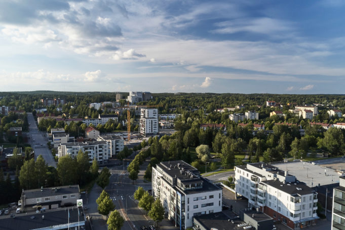 Nokian keskusta kuvattuna ilmasta kesällä 2020. Etualalla näkyy matalampia vaaleita kerrostaloja ja takana uusi korkeampi kerrostalo. Talojen väleissä on viheralueita.