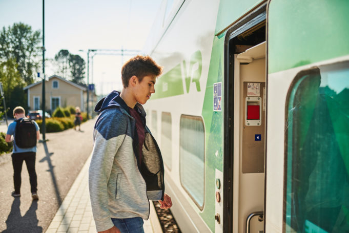 Nuori poika nousemassa junaan Nokian rautatieaseman laiturilla.