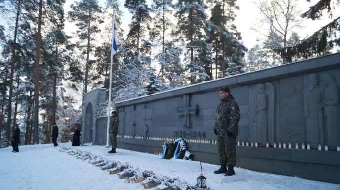 Reserviläisjärjestöjen kunniavartio Nokian pääkirkon sankarihaudalla. Kuvassa seisoo kaksi miestä maastopuvuissa sankarihaudalle lasketun seppeleen molemmin puolin.