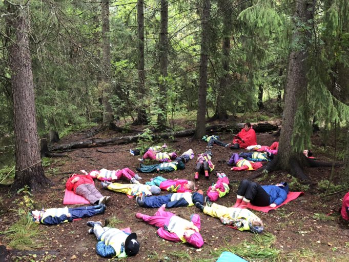 Alhoniityn päiväkodin lapset makaavat metsän keskellä maassa luontorentoutushetkessä.