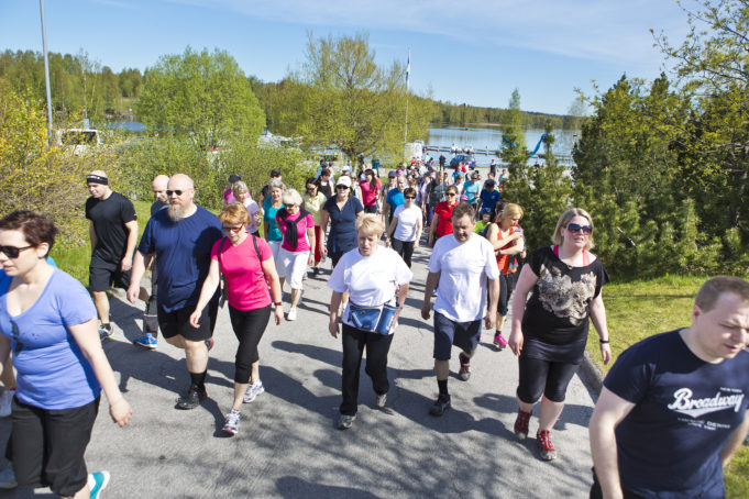 Joukko ihmisiä lähdössä Nokian kympille pyhäjärven rannasta Edenin pihasta